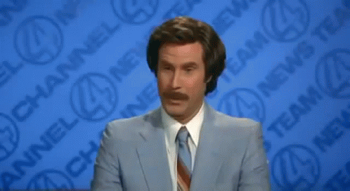 A Man In A Suit And Tie Is Standing In Front Of A Channel 4 News Wall GIF
