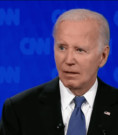 A Man In A Suit And Tie Is Standing In Front Of A Cnn Background GIF