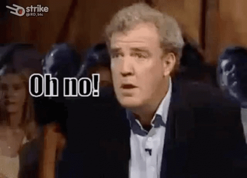 A Man In A Suit And Tie Is Standing In Front Of A Crowd And Saying Oh No . GIF