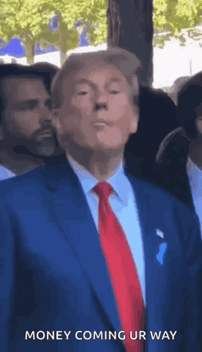 A Man In A Suit And Tie Is Standing In Front Of A Crowd And Says Money Coming Ur Way . GIF