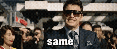 A Man In A Suit And Tie Is Standing In Front Of A Crowd Of People And Says Same . GIF