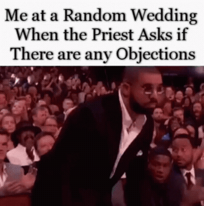 A Man In A Suit And Tie Is Standing In Front Of A Crowd Of People At A Wedding . GIF
