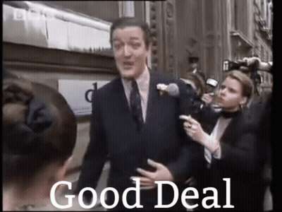 A Man In A Suit And Tie Is Standing In Front Of A Crowd Of People With The Words `` Good Deal '' Written Below Him . GIF