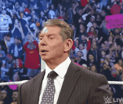 A Man In A Suit And Tie Is Standing In Front Of A Crowd With A Sign That Says " I Love You " GIF