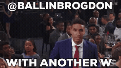 A Man In A Suit And Tie Is Standing In Front Of A Crowd With Another W Written On The Bottom GIF