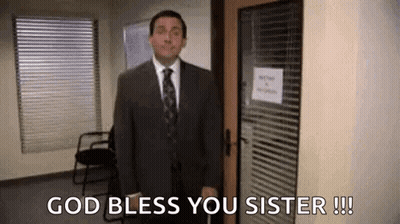A Man In A Suit And Tie Is Standing In Front Of A Door And Says `` God Bless You Sister '' . GIF