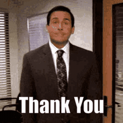 A Man In A Suit And Tie Is Standing In Front Of A Door And Says Thank You . GIF