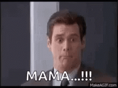 A Man In A Suit And Tie Is Standing In Front Of A Door . GIF