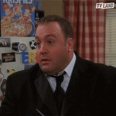 A Man In A Suit And Tie Is Standing In Front Of A Fridge With A Box Of Cereal On It . GIF
