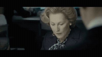 A Man In A Suit And Tie Is Standing In Front Of A Group Of Men And The Words Sink It Are Written In Yellow . GIF