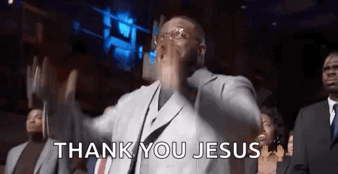 A Man In A Suit And Tie Is Standing In Front Of A Group Of People And Saying `` Thank You Jesus '' . GIF