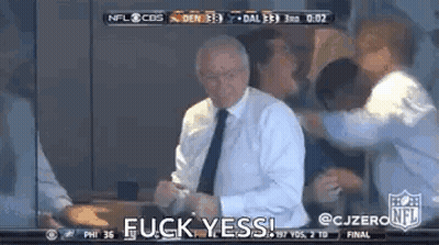 A Man In A Suit And Tie Is Standing In Front Of A Group Of People And Says Fuck Yes . GIF