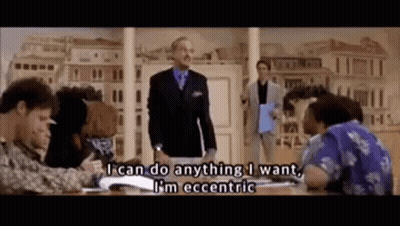 A Man In A Suit And Tie Is Standing In Front Of A Group Of People And Says I Can Do Anything I Want . GIF