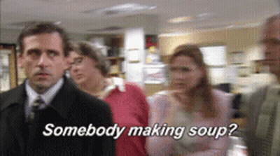 A Man In A Suit And Tie Is Standing In Front Of A Group Of People And Says Somebody Making Soup GIF