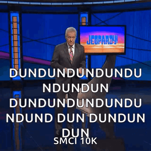 A Man In A Suit And Tie Is Standing In Front Of A Jeopardy Screen GIF