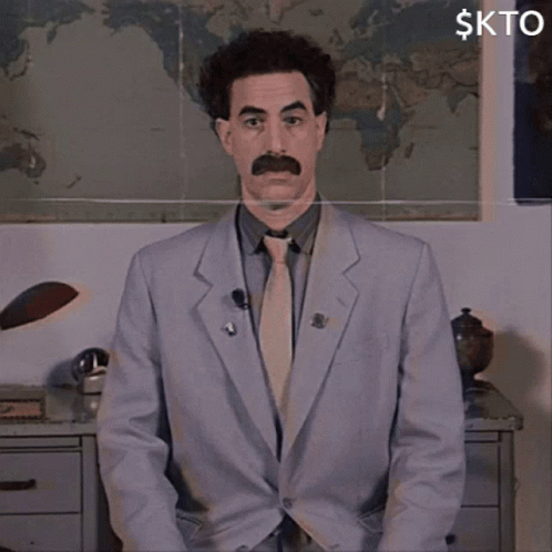 A Man In A Suit And Tie Is Standing In Front Of A Map And A Sign That Says Kto GIF