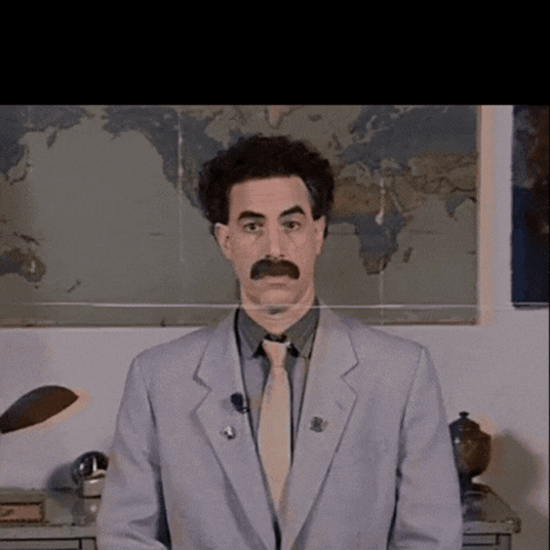 A Man In A Suit And Tie Is Standing In Front Of A Map GIF