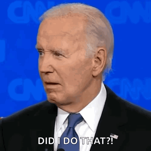 A Man In A Suit And Tie Is Standing In Front Of A Microphone And Making A Funny Face . GIF