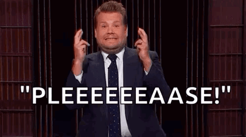 A Man In A Suit And Tie Is Standing In Front Of A Microphone And Making A Gesture With His Hands . GIF