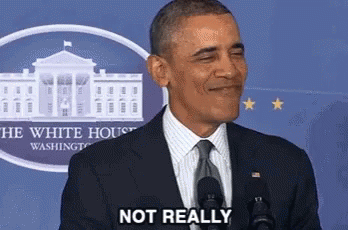 A Man In A Suit And Tie Is Standing In Front Of A Microphone And Smiling . GIF