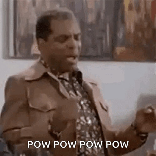 A Man In A Suit And Tie Is Standing In Front Of A Microphone And Talking . GIF