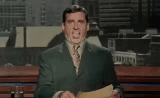 A Man In A Suit And Tie Is Standing In Front Of A Microphone Holding A Piece Of Paper . GIF