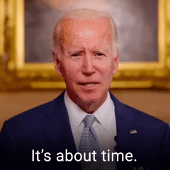 A Man In A Suit And Tie Is Standing In Front Of A Picture And Says `` It 'S About Time '' . GIF