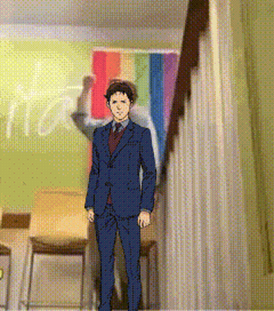 A Man In A Suit And Tie Is Standing In Front Of A Rainbow Flag In A Room GIF