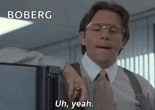 A Man In A Suit And Tie Is Standing In Front Of A Refrigerator In An Office . GIF