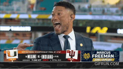 A Man In A Suit And Tie Is Standing In Front Of A Screen That Says Marcus Freeman GIF