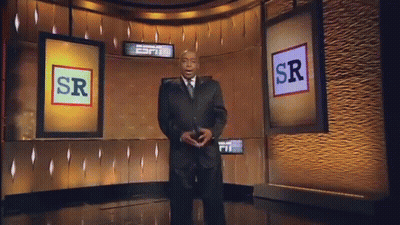 A Man In A Suit And Tie Is Standing In Front Of A Screen That Says Sr GIF