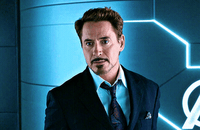 A Man In A Suit And Tie Is Standing In Front Of A Sign That Has The Letter O On It GIF