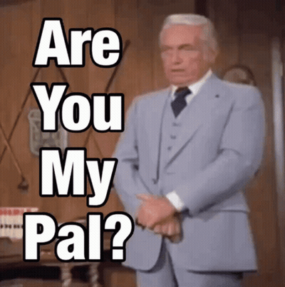 A Man In A Suit And Tie Is Standing In Front Of A Sign That Says " Are You My Pal " GIF