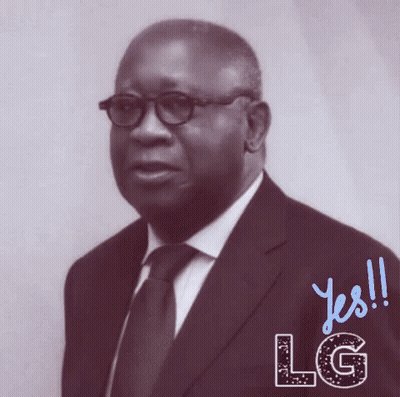 A Man In A Suit And Tie Is Standing In Front Of A Sign That Says Lg GIF