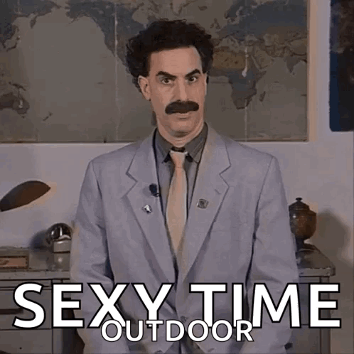 A Man In A Suit And Tie Is Standing In Front Of A Sign That Says Sexy Time Outside GIF