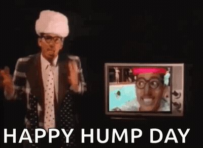 A Man In A Suit And Tie Is Standing In Front Of A Television And Waving His Hand . GIF