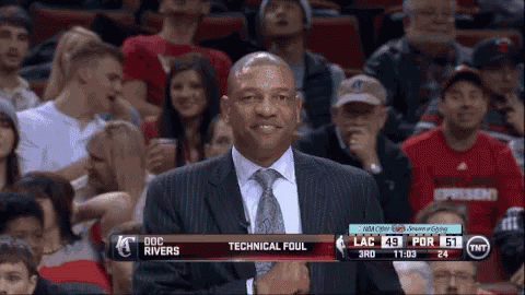 A Man In A Suit And Tie Is Standing In Front Of A Tnt Advertisement GIF