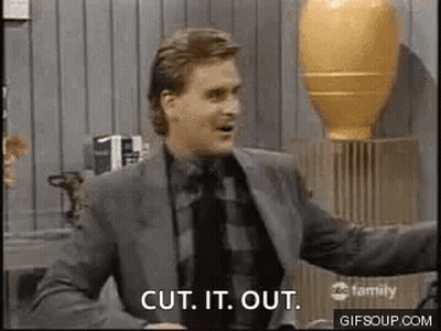 A Man In A Suit And Tie Is Standing In Front Of A Vase . GIF
