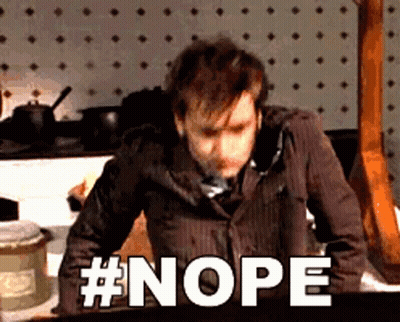 A Man In A Suit And Tie Is Standing In Front Of A Wall That Says Nope GIF