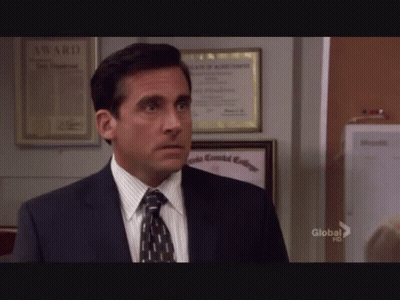 A Man In A Suit And Tie Is Standing In Front Of A Wall With A Framed Certificate That Says Award On It GIF