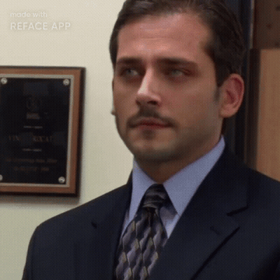 A Man In A Suit And Tie Is Standing In Front Of A Wall With A Plaque On It That Says Reface App On It GIF