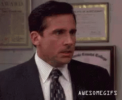 A Man In A Suit And Tie Is Standing In Front Of A Wall With Awards On It . GIF