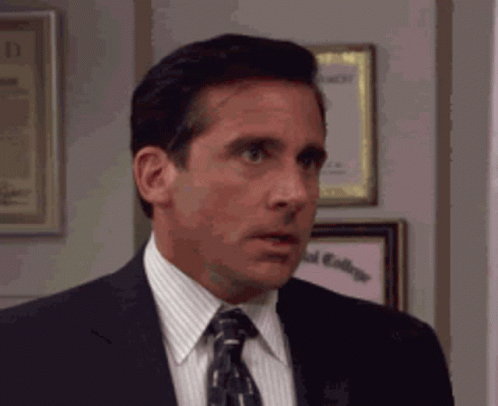Man In Suit And Tie In Front Of Framed Pictures GIF