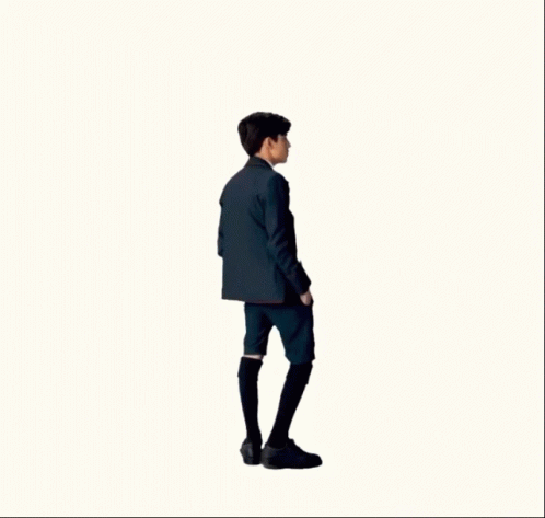 A Man In A Suit And Tie Is Standing In Front Of A White Background GIF