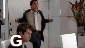 A Man In A Suit And Tie Is Standing In Front Of A White Board With The Letter G On It GIF