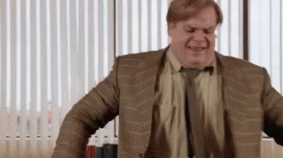 A Man In A Suit And Tie Is Standing In Front Of A Window In An Office . GIF
