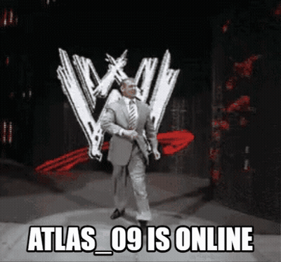 A Man In A Suit And Tie Is Standing In Front Of A Wwe Logo GIF
