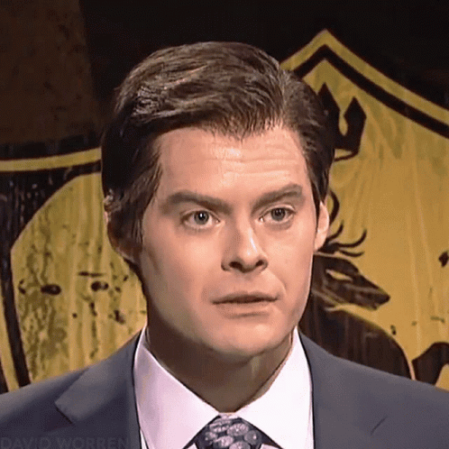 A Man In A Suit And Tie Is Standing In Front Of A Yellow Shield That Says David Worren GIF