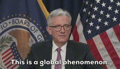 A Man In A Suit And Tie Is Standing In Front Of An American Flag And Says This Is A Global Phenomenon GIF
