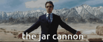 A Man In A Suit And Tie Is Standing In Front Of Mountains And The Words The Jar Cannon GIF